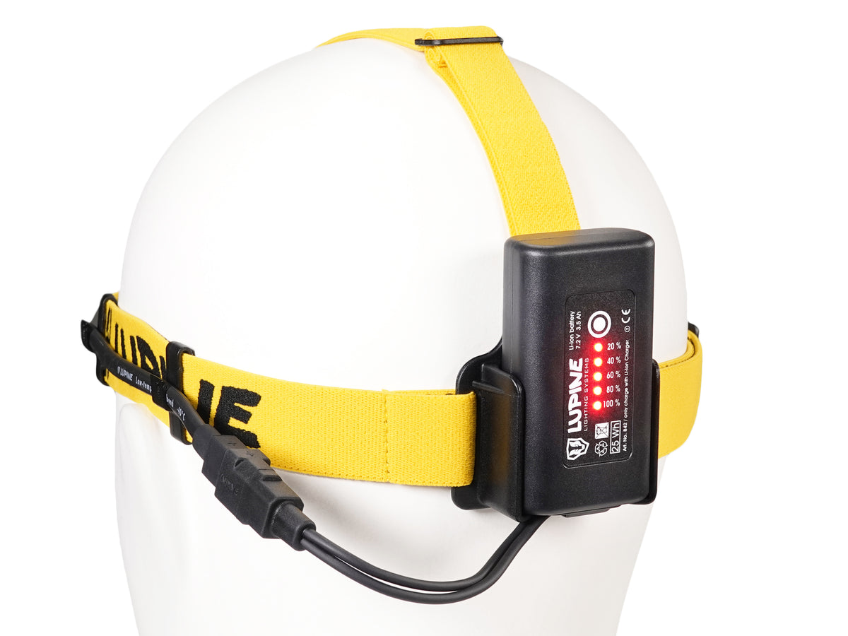 3.5 Ah SmartCore battery attached with FastClick at the back of the yellow-black headband, capacity indicator lit