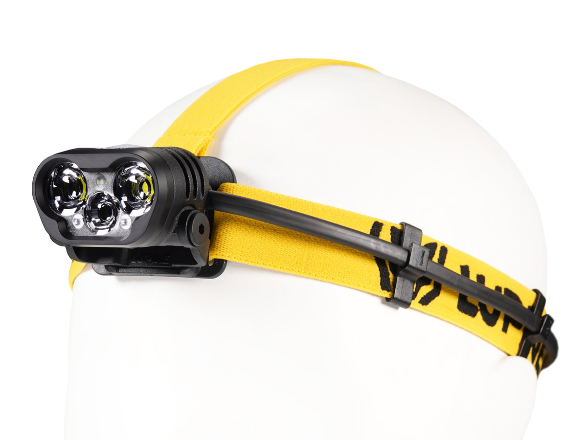 Blika headlamp on the yellow-black headband, side view with cable routing