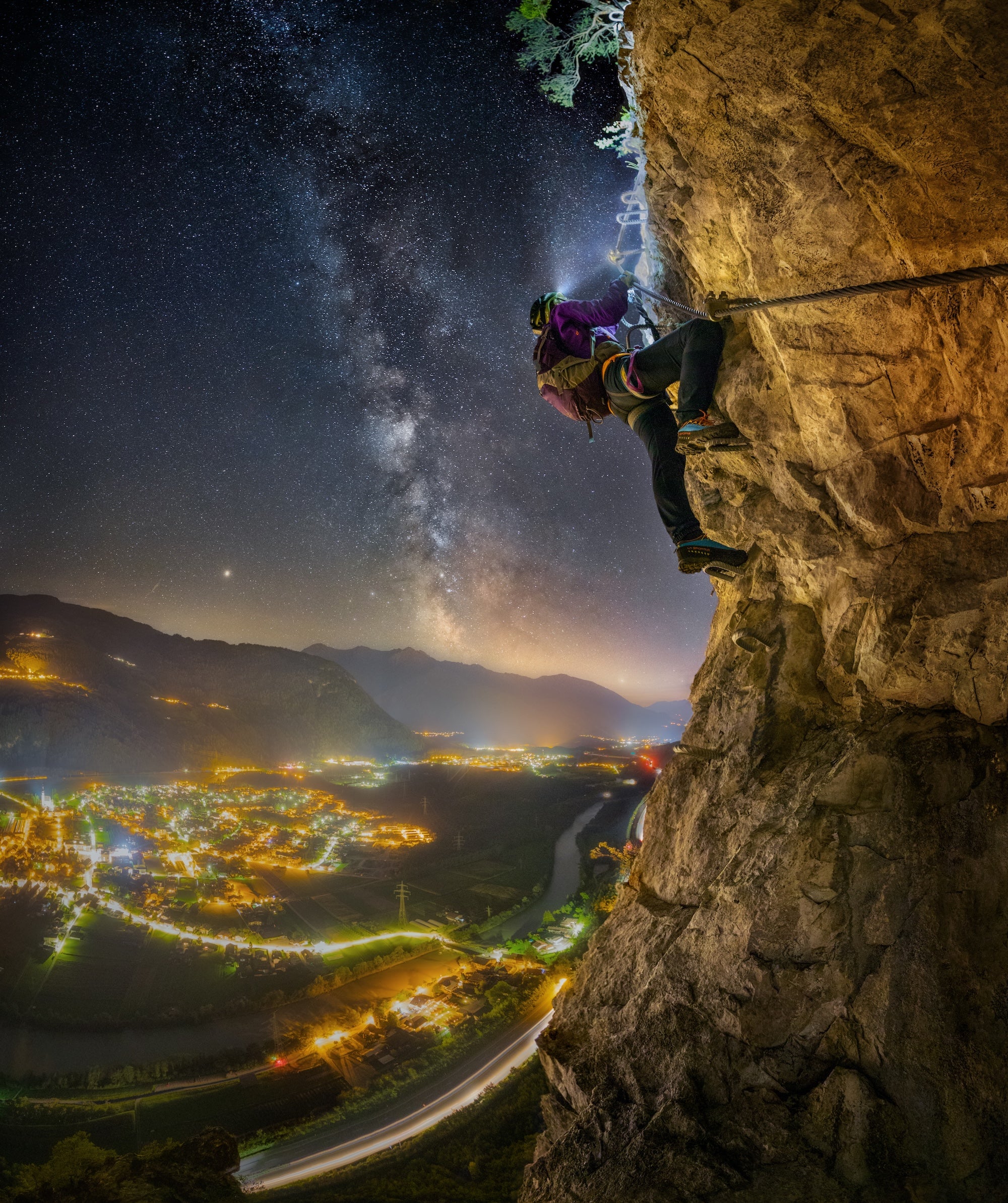 climber with Lupine headlamp on a rock face at dusk