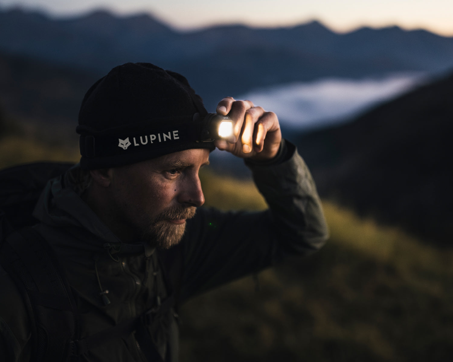 Person mit Lupine Penta Stirnlampe in der Dämmerung